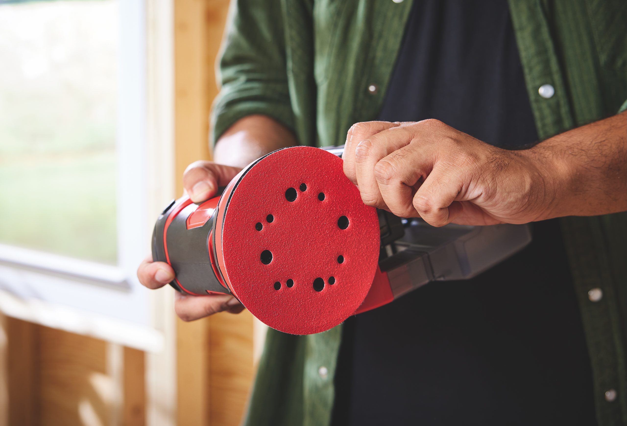 Man holding orbital sander.